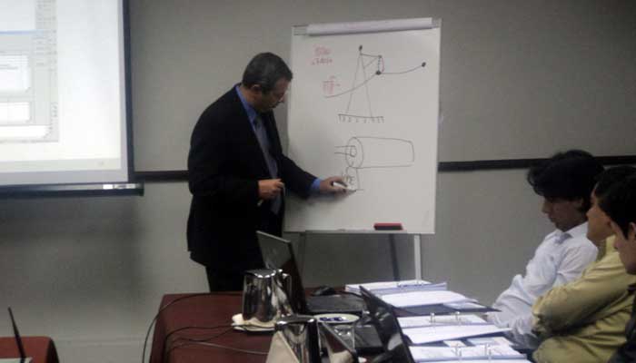 El expositor Flavio Fernández de DigSilent explica algunos detalles en la pizarra
